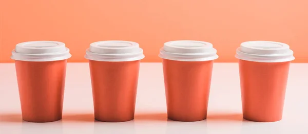 Coral disposable cups on coral background, color of 2019 concept — Stock Photo