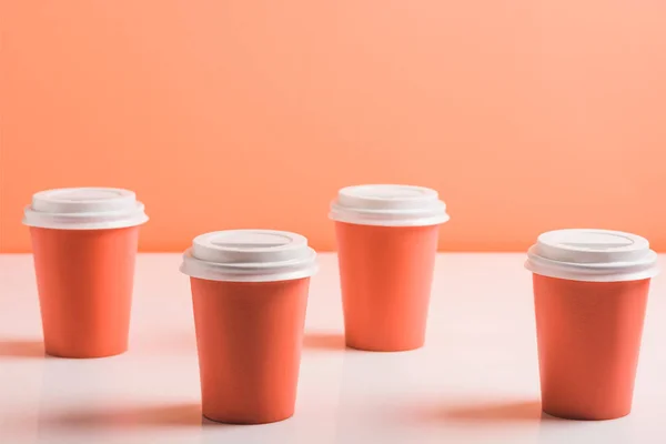 Tazas desechables de coral sobre fondo de coral, concepto de color de 2019 — Stock Photo