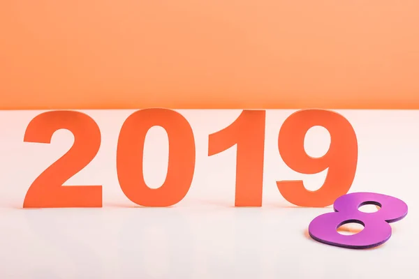 Papel coral cortar 2019 números y violeta número 8 en la superficie blanca, el color del concepto 2019 - foto de stock