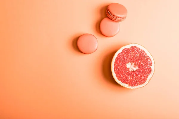 Vista superior de macarons de coral e toranja metade no fundo de coral, cor do conceito 2019 — Fotografia de Stock