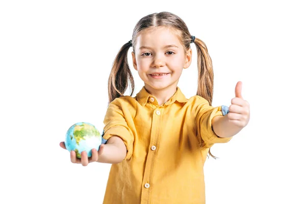 Enfant mignon tenant modèle de globe et montrant pouce vers le haut isolé sur blanc, concept de jour de la terre — Photo de stock