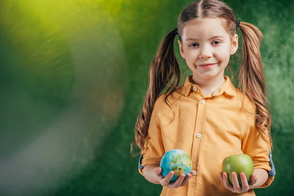 Child holding globe model and apple on blurred background on blurred background, earth day concept — Stock Photo