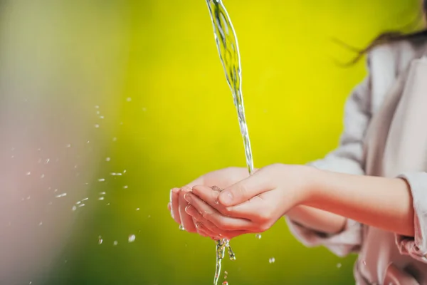 Selektiver Fokus des Kindes, das die Hände unter fließendem Wasser hält, auf verschwommenem Hintergrund, Earth Day-Konzept — Stockfoto