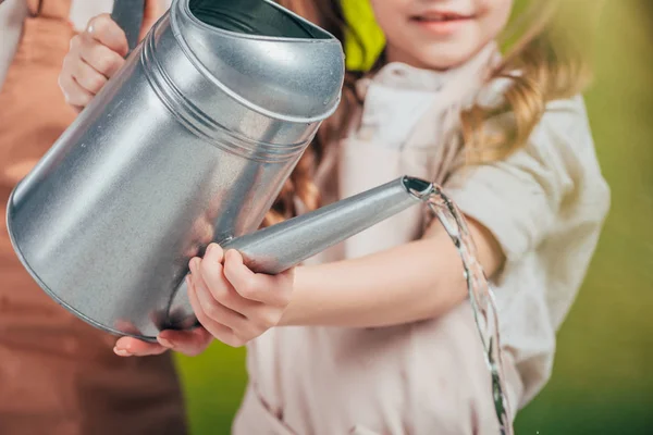 Foyer sélectif de la femme et de l'enfant avec arrosoir sur fond flou, concept de jour de la terre — Photo de stock