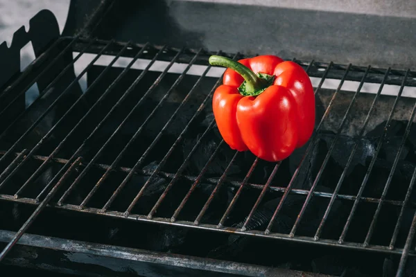 Bright red fresh bell pepper on bbq grill grates — Stock Photo