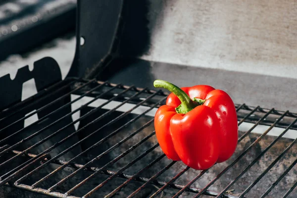 Bright red fresh bell pepper on bbq grill grates — Stock Photo