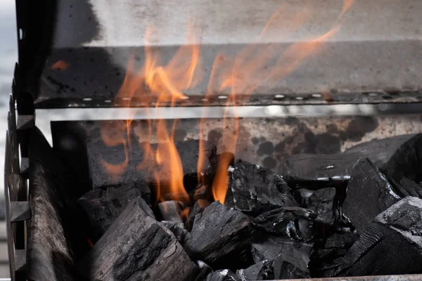 Bright burning black coals in iron barbecue grill — Stock Photo