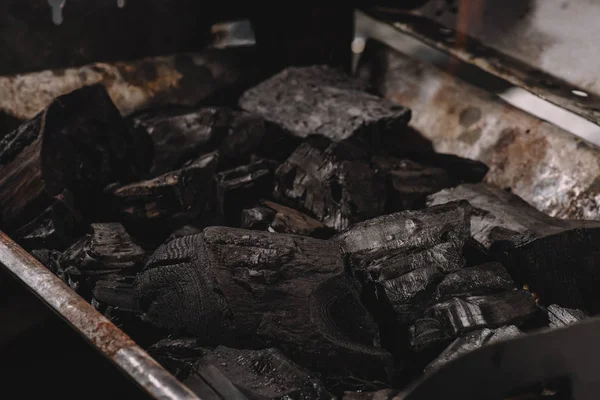 Pila de carbones negros oscuros en barbacoa de hierro - foto de stock