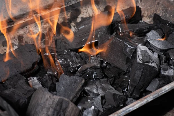 Bright burning black coals in iron barbecue grill — Stock Photo