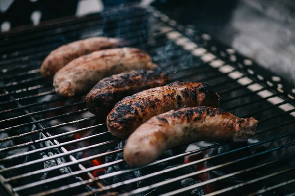 Saucisses de viande brune grillées sur grille de barbecue — Photo de stock