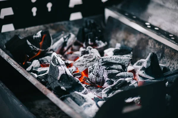 Selective focus of hot burning coals with ash in iron bbq grill — Stock Photo