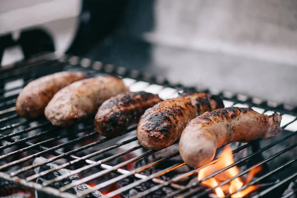 Focus selettivo di gustose salsicce grigliate sulla griglia barbecue — Foto stock