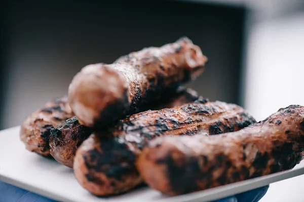 Enfoque selectivo de deliciosas salchichas de carne con corteza en plato blanco - foto de stock