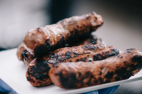 Selective focus of delicious meat sausages with crust on white plate — Stock Photo