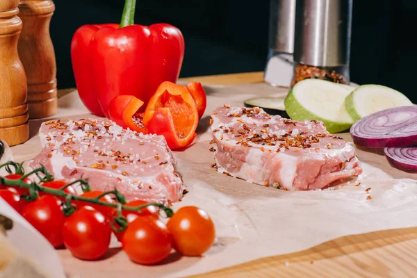 Steaks crus avec assaisonnement et légumes frais mûrs — Photo de stock