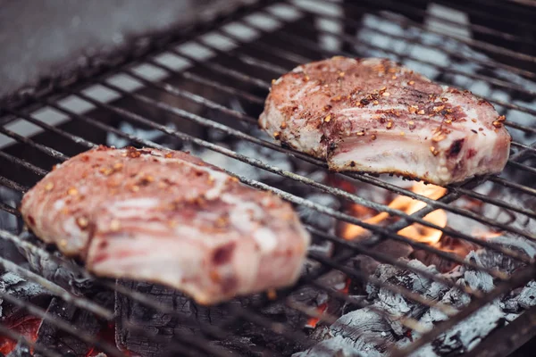 Selective focus of juicy raw steaks grilling on barbecue grid — Stock Photo