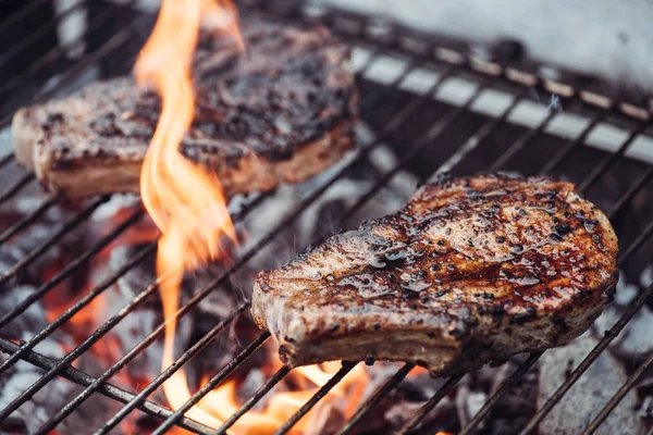 Foyer sélectif de steaks juteux grillades savoureuses sur barbecue grill grade avec flamme — Photo de stock