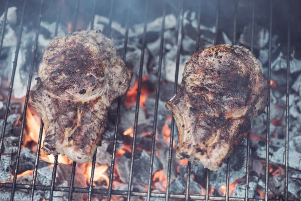 Bifes saborosos suculentos grelhando no grau churrasqueira com fumaça — Fotografia de Stock