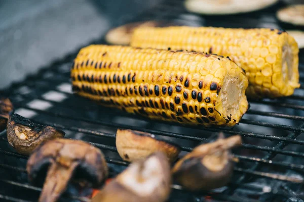 Messa a fuoco selettiva di mais giallo con crosta e funghi grigliate su griglia barbecue — Foto stock