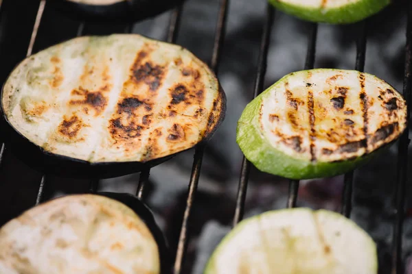 Close up of delicious eggplant and zucchini slices grilling on barbecue grid — Stock Photo