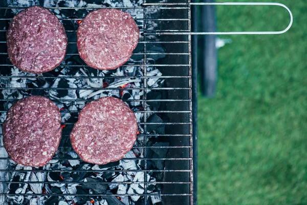 Vue de dessus des escalopes de hamburger frais grillades sur grille de barbecue — Photo de stock