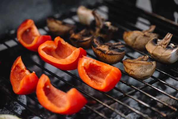 Selective focus of red bell pepper and mushrooms grilling on barbecue grill grade — Stock Photo