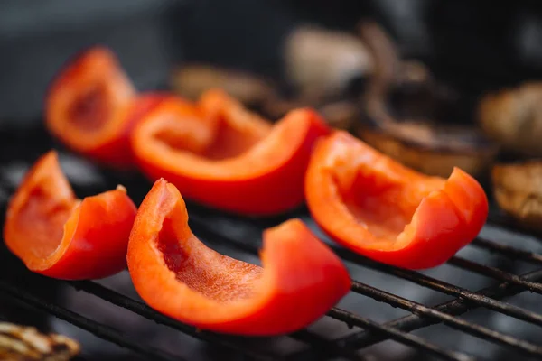 Close up of red fresh bell pepper slices grilling on barbecue grill grade — Stock Photo