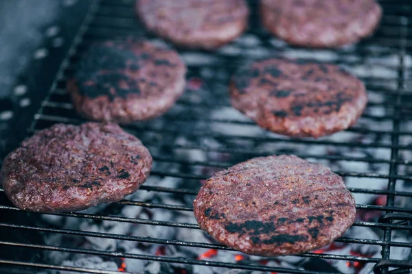 Selective focus of grilled fresh burger cutlets on bbq grid — Stock Photo