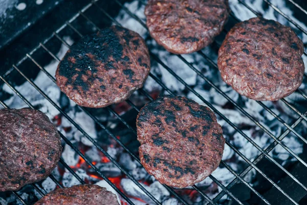 Вид на гриль свежие котлеты бургер на сетке барбекю — стоковое фото