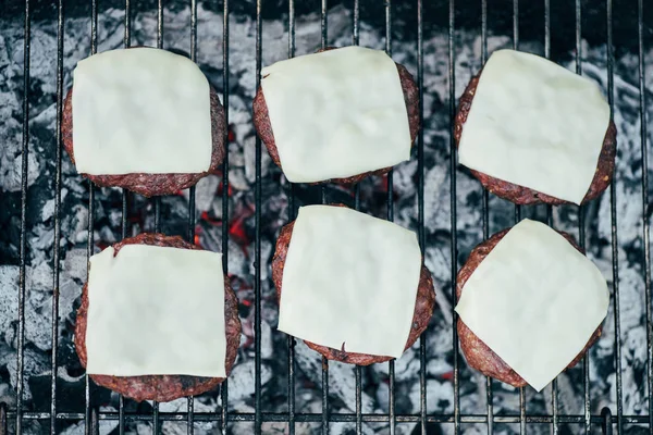 Vista superior de deliciosas croquetas de hamburguesa con queso a la parrilla en la parrilla de barbacoa - foto de stock