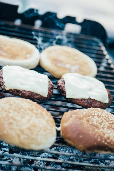 Selective focus of delicious fresh burgers ingredients grilling on barbecue grid — Stock Photo