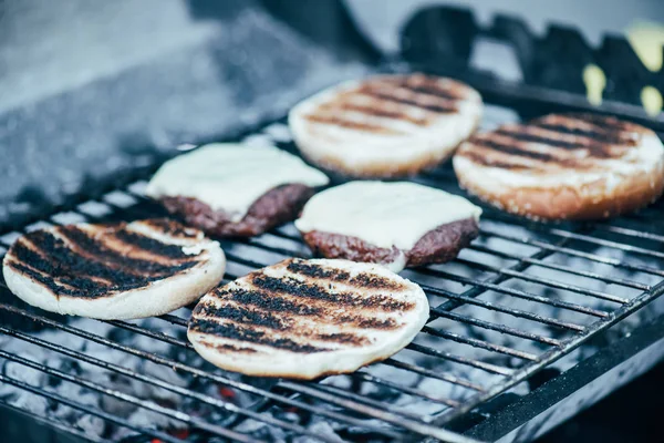 Messa a fuoco selettiva di deliziosi ingredienti freschi hamburger con crosta grigliate sulla griglia barbecue — Foto stock