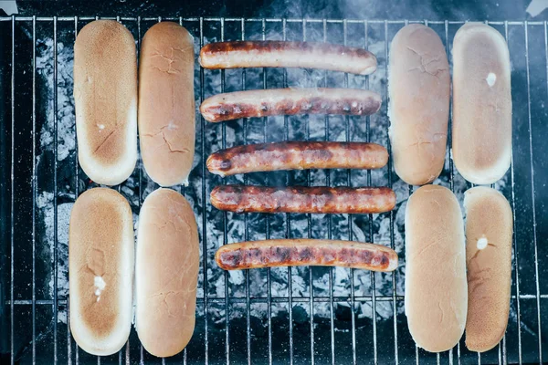 Vista dall'alto di gustosi hot dog grigliate con fumo sulla griglia barbecue grado — Foto stock