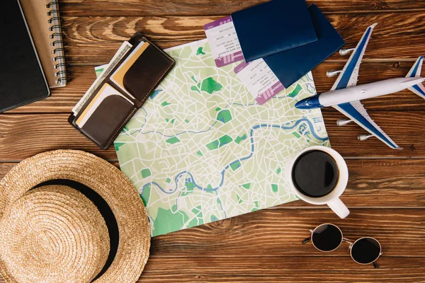 Top view of accessories, map, passports with tickets and plane model on wooden surface — Stock Photo