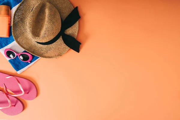 Draufsicht auf Sommer-Accessoires und Sonnencreme auf orangefarbenem Hintergrund — Stockfoto