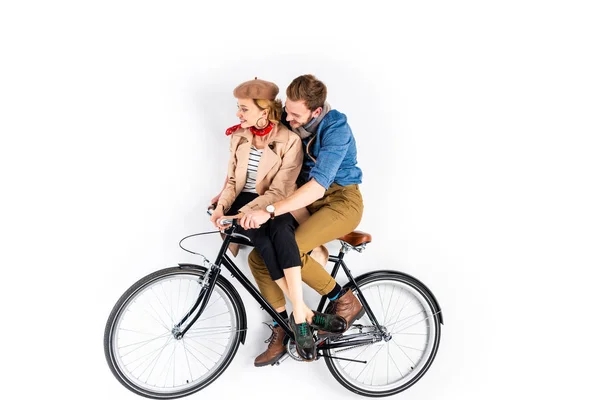 Sonriendo pareja elegante montar bicicleta juntos sobre fondo blanco - foto de stock