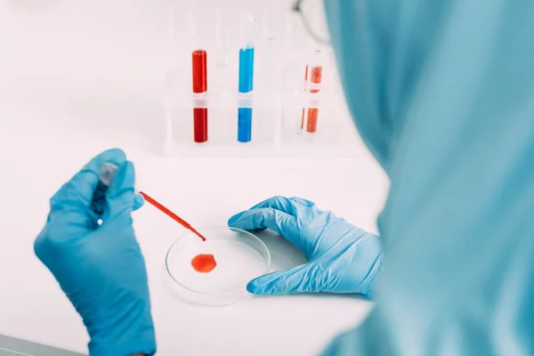 Обрезанный взгляд на женщину-ученого, делающую анализ крови в лаборатории — стоковое фото
