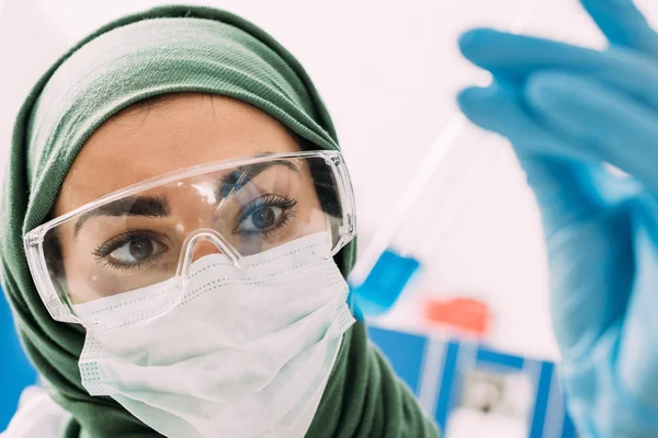 Selektiver Fokus muslimischer Wissenschaftlerin mit Reagenzglas im Labor — Stockfoto