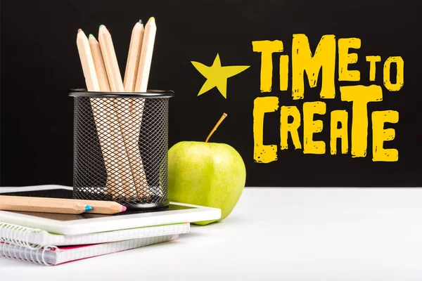 Fresh apple, notebooks and color pencils on table with time to create lettering and star on black — Stock Photo