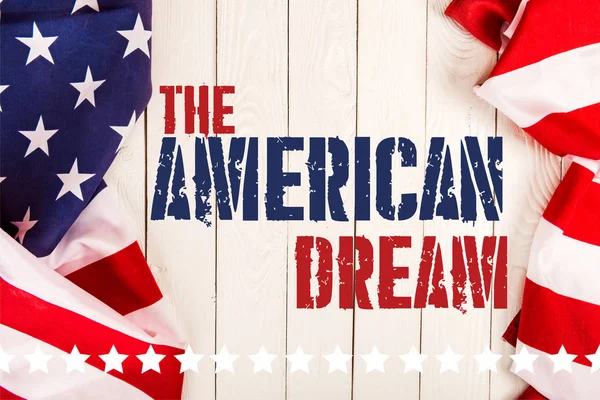Vista dall'alto delle bandiere americane e delle scritte da sogno americane su una superficie di legno bianca — Foto stock