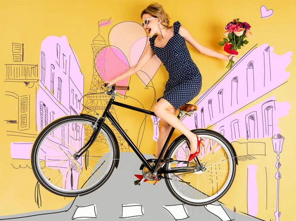 Vue de dessus de jeune femme élégante heureuse avec bouquet de roses et vélo couché sur fond jaune avec illustration de rue de la ville — Photo de stock