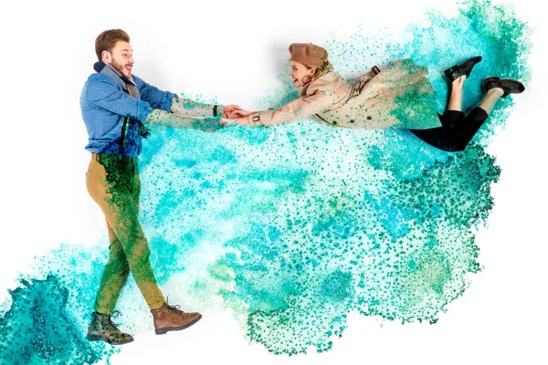 Elegante Frau schwebt in der Luft und hält Händchen mit Mann auf Hintergrund mit Aquarell türkis verschüttet — Stockfoto