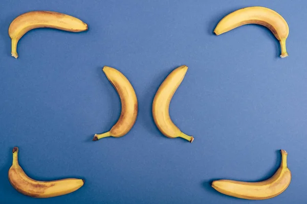 Draufsicht auf leckere, reife und gelbe Bananen auf blauem Hintergrund — Stockfoto