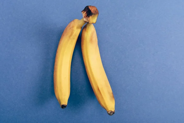 Вид сверху на два ярких и свежих банана на синем фоне — стоковое фото