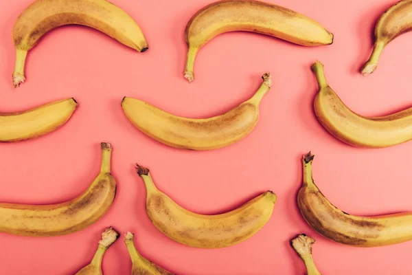 Top view of yellow and ripe bananas on coral background — Stock Photo