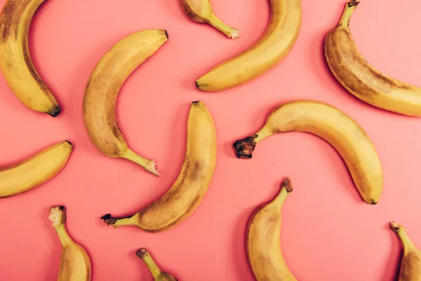 Top view of ripe, bright and yellow bananas on coral background — Stock Photo