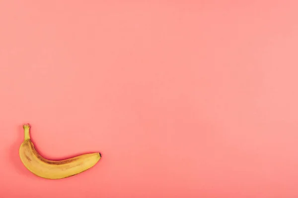 Top view of ripe, bright and yellow banana on colorful coral background with copy space — Stock Photo