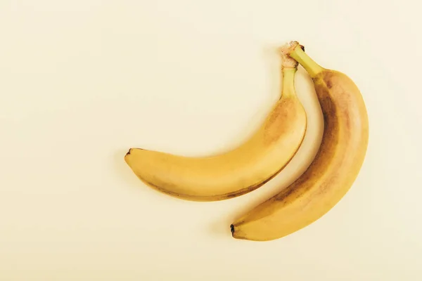 Top view of delicious and yellow bananas on light beige background — Stock Photo