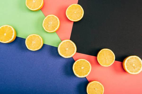 Top view of juicy and fresh cut lemons on multicolored background — Stock Photo