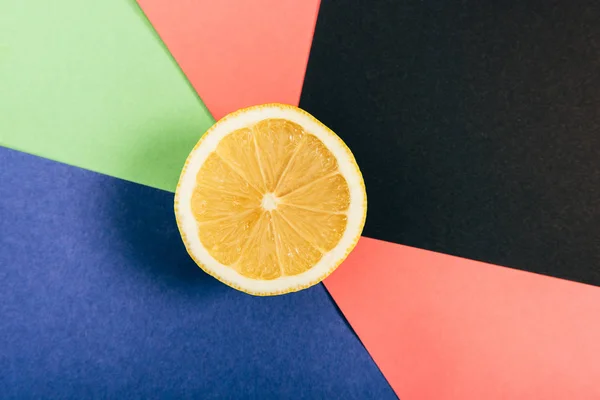 Вид зверху на соковиту і жовту половину лимона на різнокольоровому фоні — стокове фото